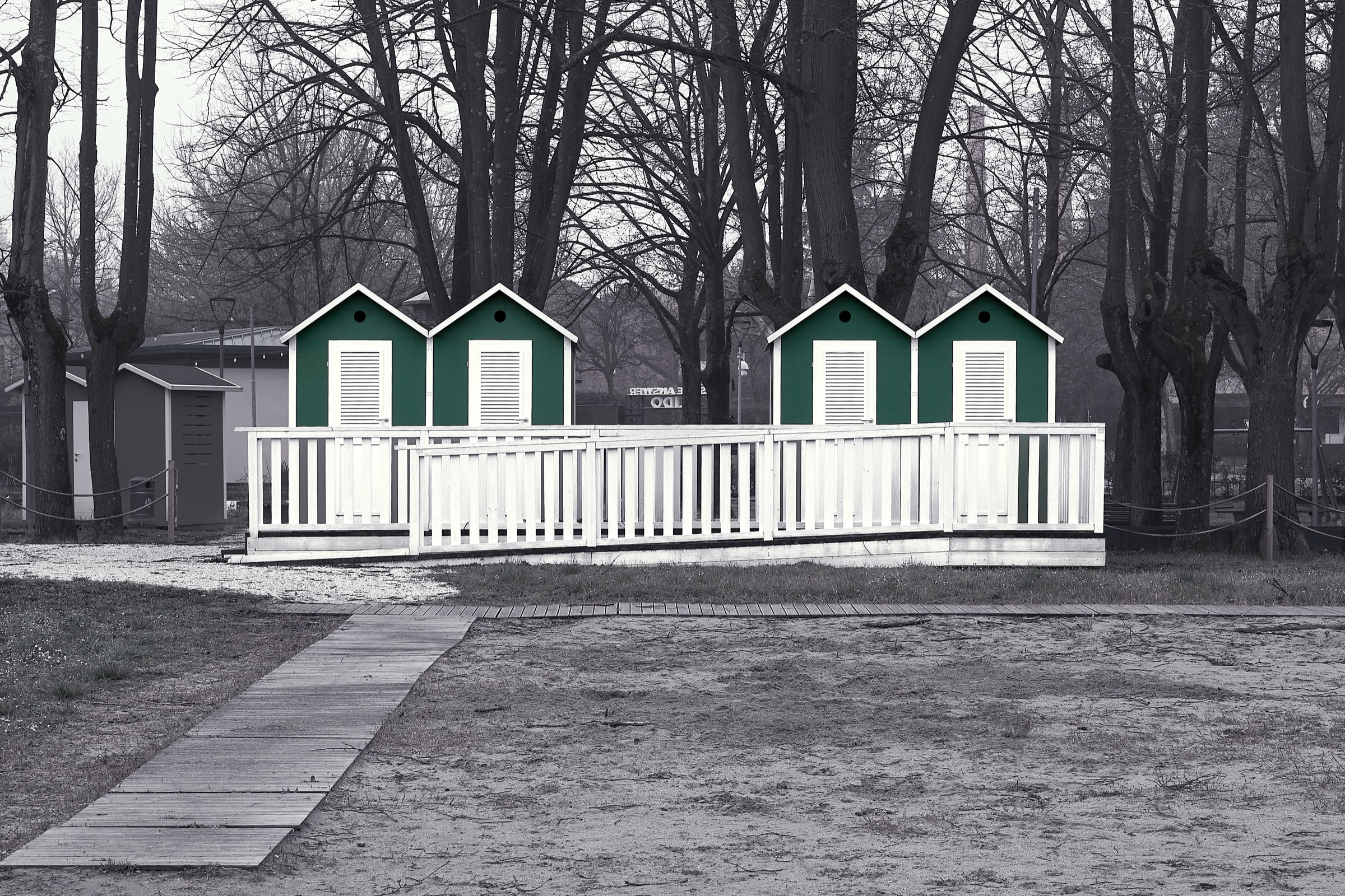 Cabine sulla spiaggia in bianco e nero con dettaglio verde